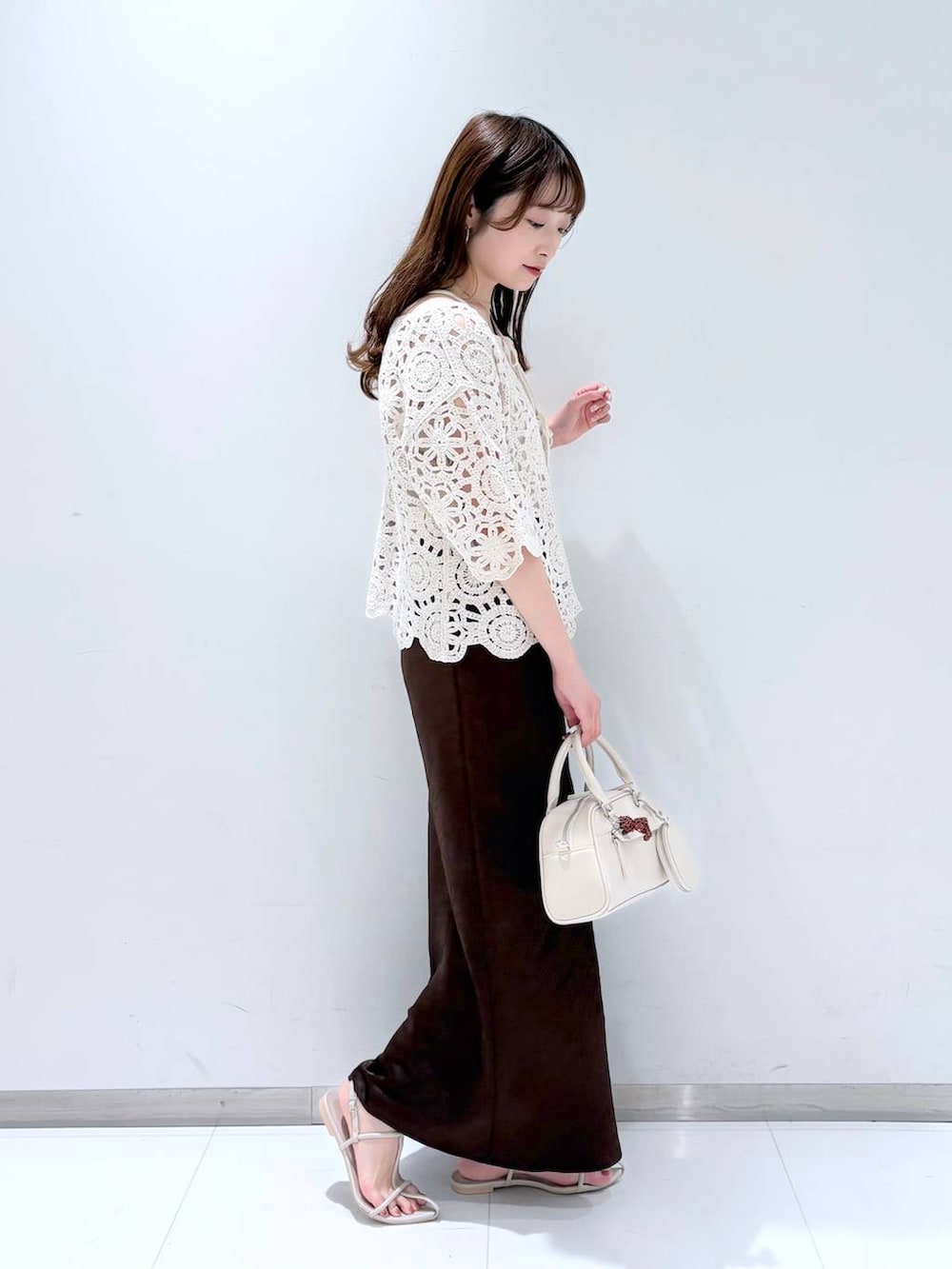 ホワイト系のTシャツ/カットソー、ホワイト系のサンダル、ブラウン系のスカートを着用したレディースの春コーディネートの2枚目の写真