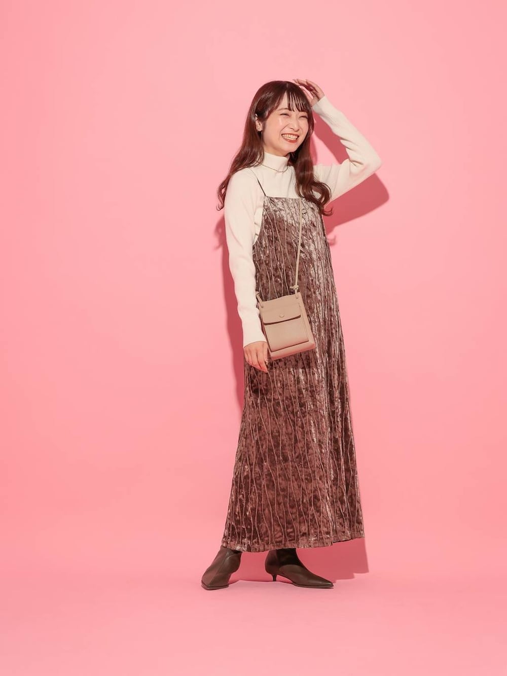 ホワイト系のニット/セーター、ブラウン系のブーツ、ゴールド系のネックレスを着用したレディースの冬コーディネートの2枚目の写真