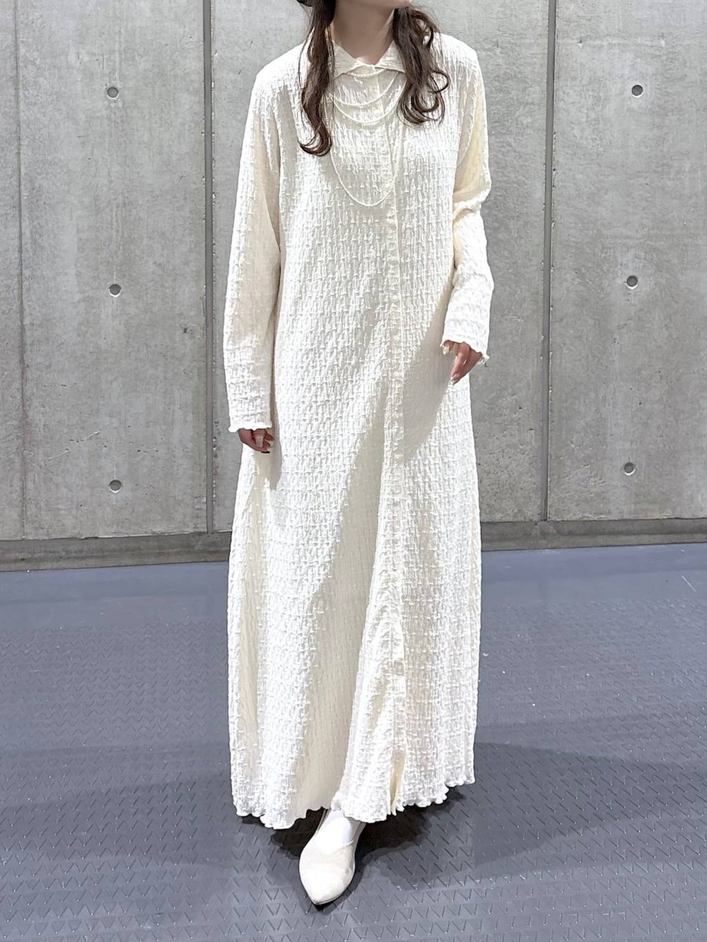 ホワイト系のスカート、ホワイト系のパンプス、ホワイト系のワンピースを着用したレディースの冬コーディネートの3枚目の写真