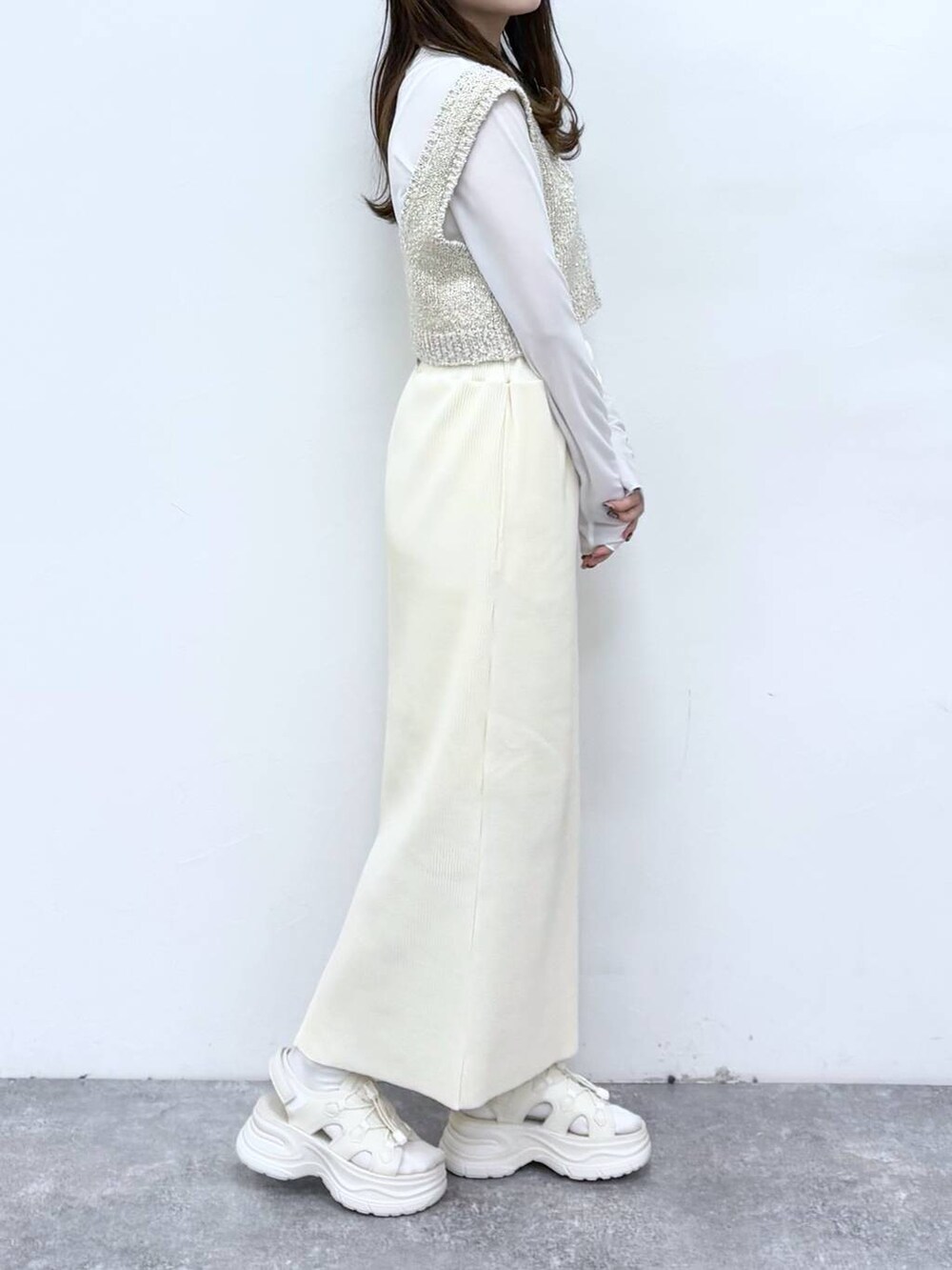 ホワイト系のTシャツ/カットソー、ホワイト系のスカート、ホワイト系のサンダルを着用したレディースの冬コーディネートの2枚目の写真