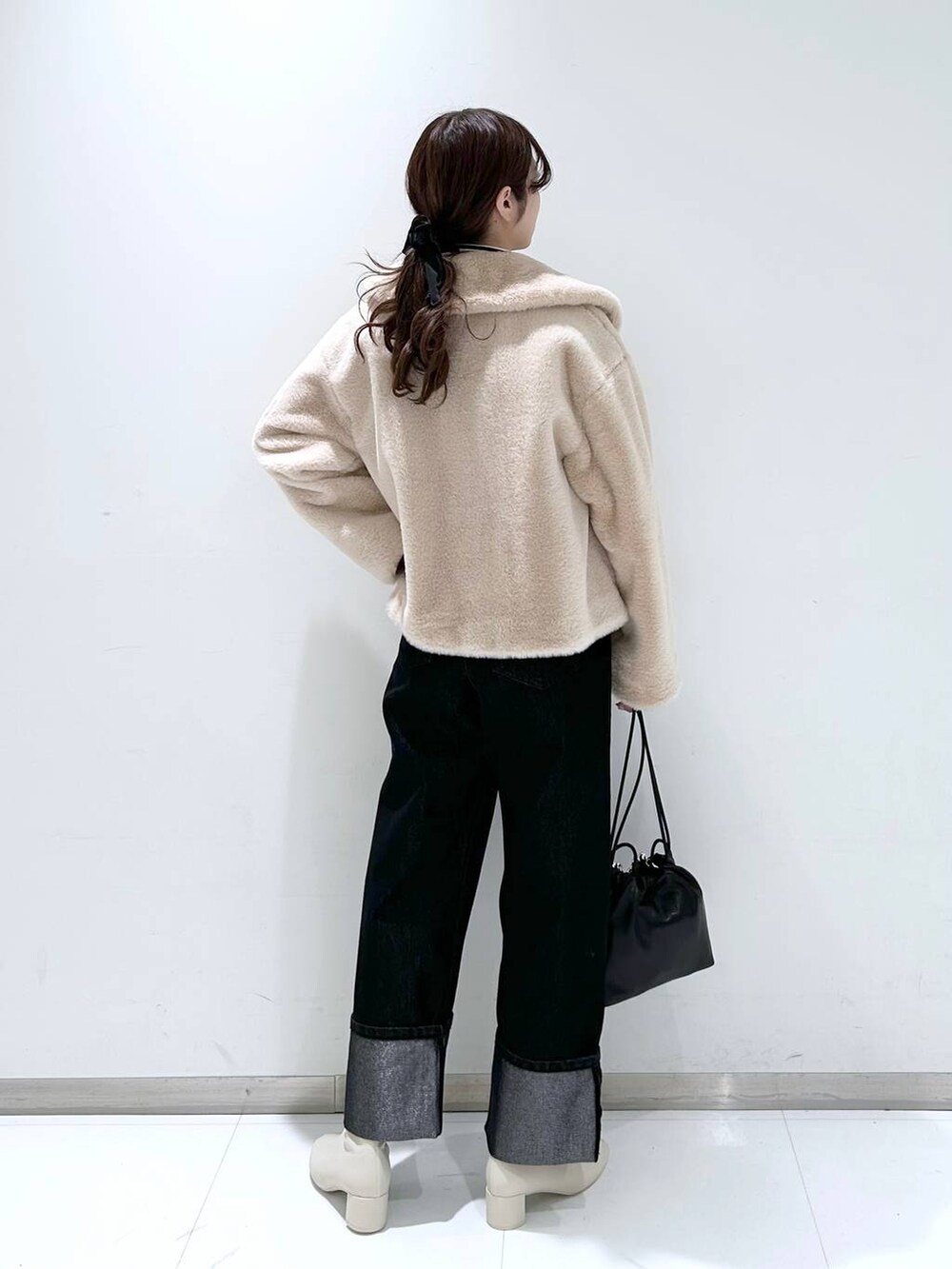 その他のニット/セーター、ホワイト系のブーツ、ブラック系のショルダーバッグを着用したレディースの秋コーディネートの4枚目の写真