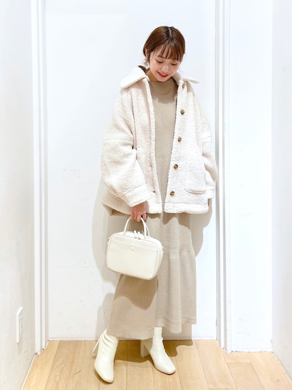 ホワイト系のブルゾン、ホワイト系のワンピース、ホワイト系のブーツを着用したレディースの秋コーディネートの2枚目の写真