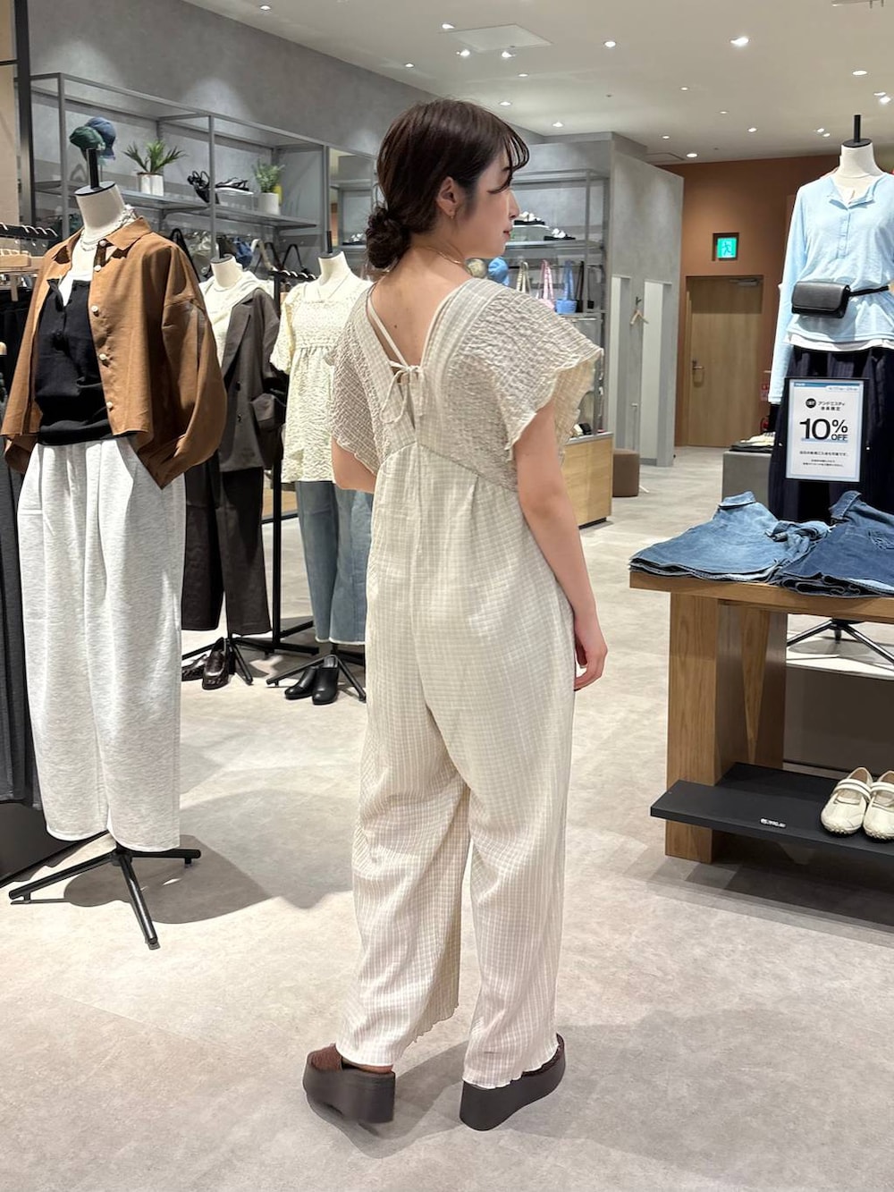 ホワイト系のTシャツ/カットソー、ベージュ系のサロペット/オーバーオール、ブラウン系のサンダルを着用したレディースの春コーディネートの3枚目の写真