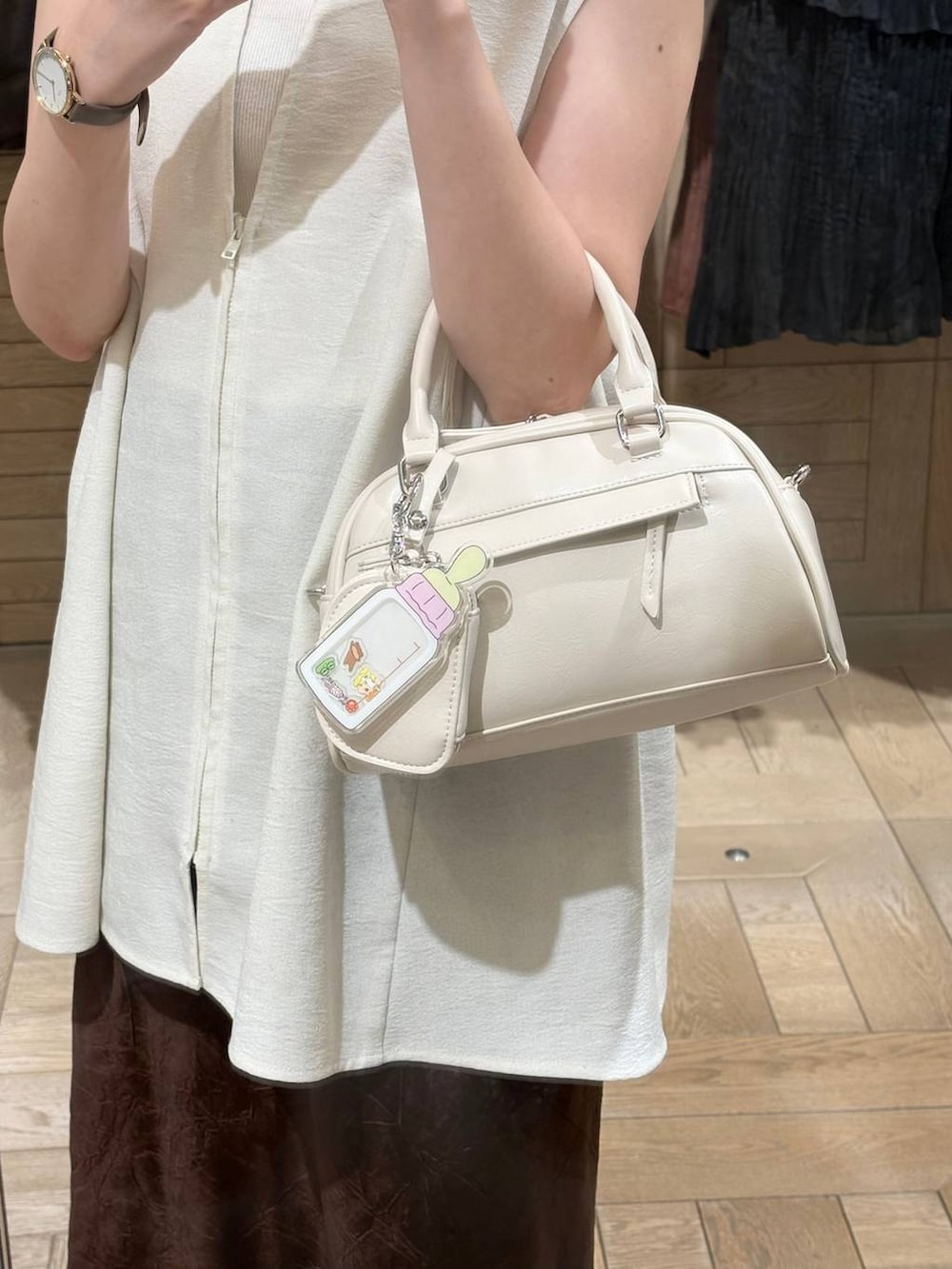 ホワイト系のTシャツ/カットソー、ホワイト系のベスト、ブラウン系のスカートを着用したレディースの夏コーディネートの2枚目の写真