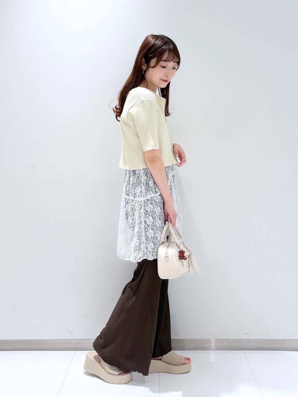 ホワイト系のTシャツ/カットソー、ホワイト系のサンダル、ブラウン系のその他パンツを着用したレディースの春コーディネートの3枚目の写真