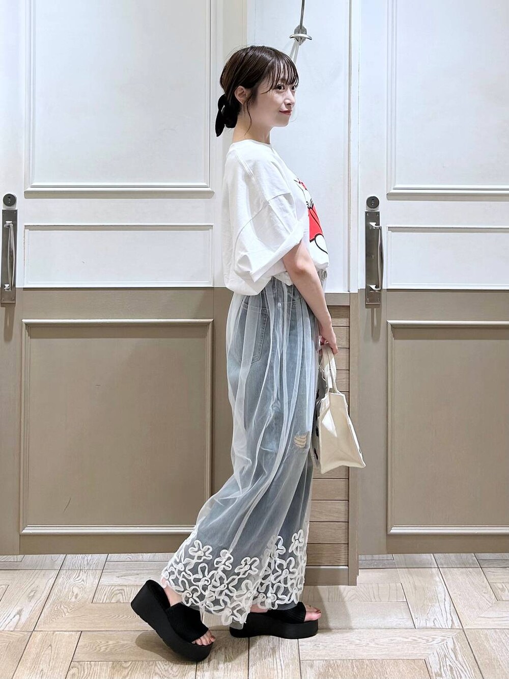 ブラック系のサンダル、ブルー系のデニムパンツ、ホワイト系のその他パンツを着用したレディースの夏コーディネートの4枚目の写真