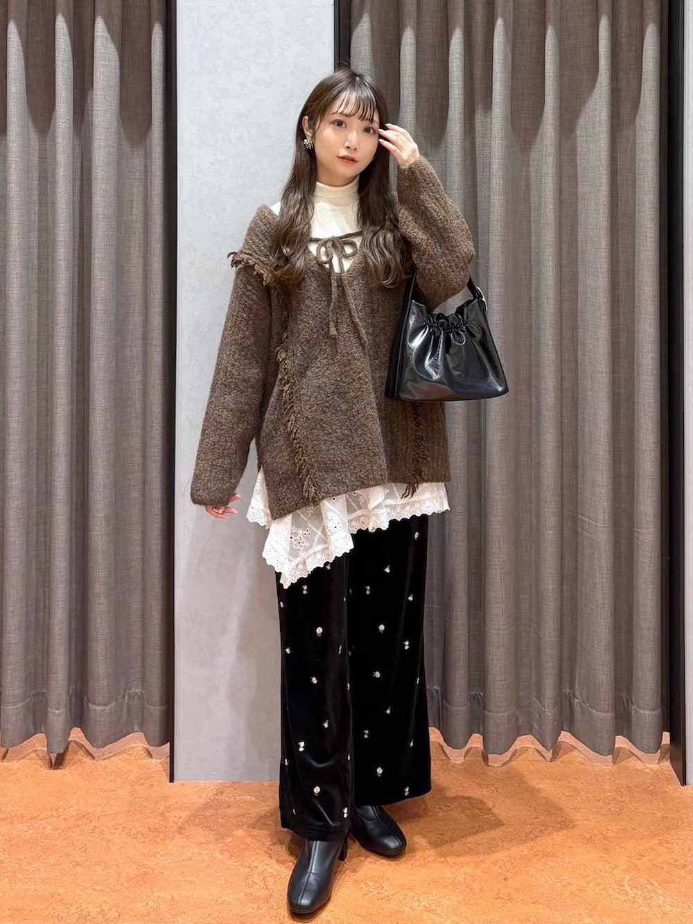 ブラウン系のニット/セーター、ホワイト系のニット/セーター、ブラウン系のムートンコートを着用したレディースの冬コーディネートの6枚目の写真