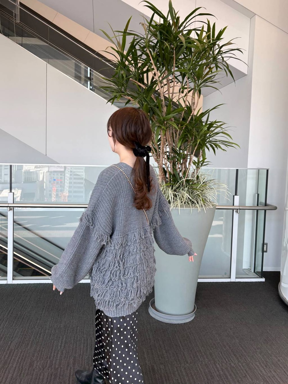 ゴールド系のショルダーバッグ、ブラック系のスカートを着用したレディースの春コーディネートの10枚目の写真