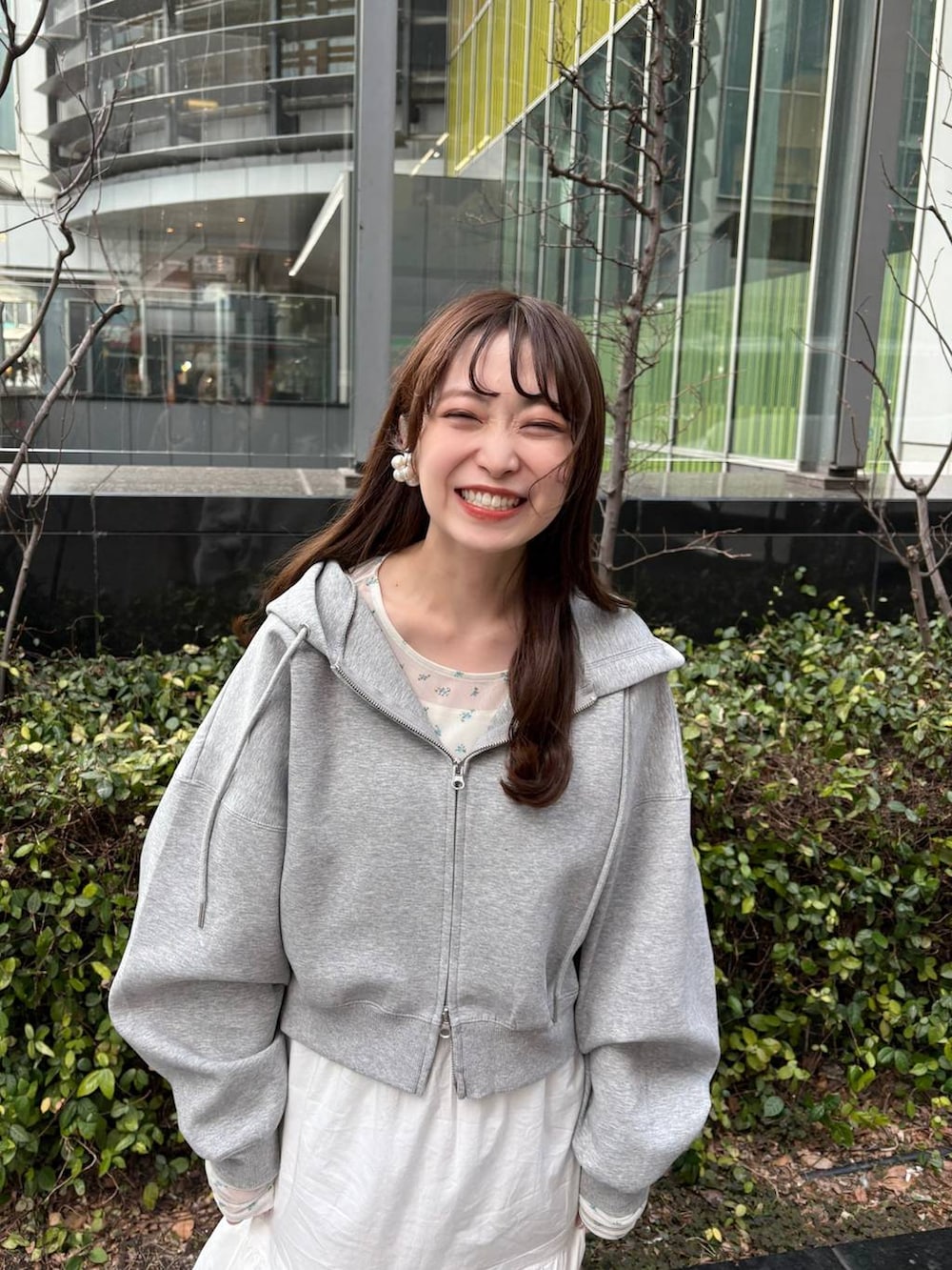 グレー系のパーカー、ホワイト系のTシャツ/カットソー、ブラウン系のローファーを着用したレディースの冬コーディネートの2枚目の写真