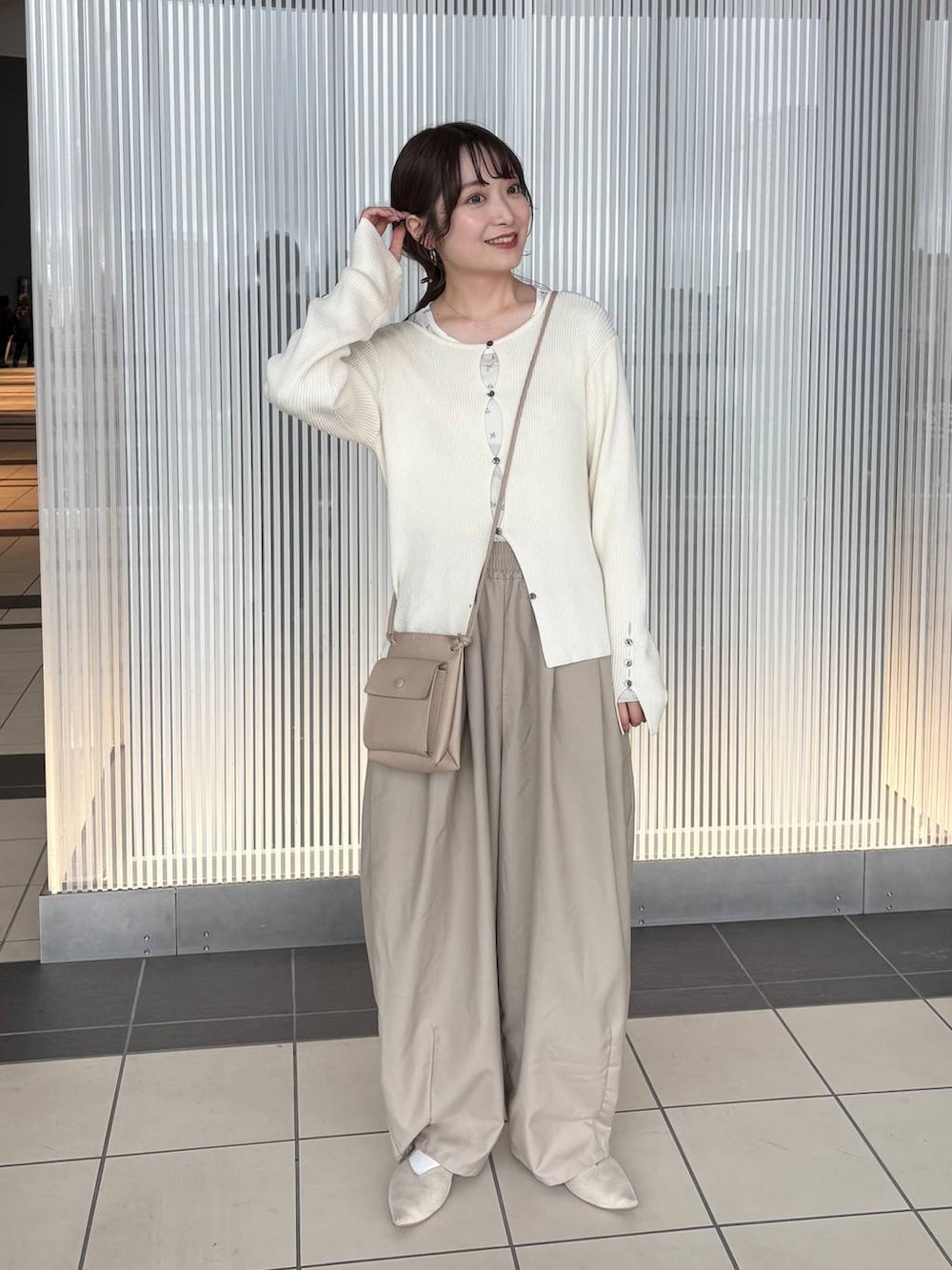 ホワイト系のニット/セーター、ベージュ系のその他パンツ、ホワイト系のTシャツ/カットソーを着用したレディースの春コーディネートの3枚目の写真