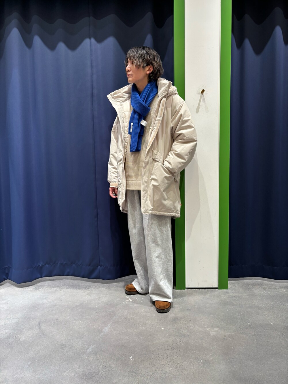 グレー系のスウェットパンツ、ホワイト系のニット/セーターを着用したメンズの冬コーディネートの2枚目の写真