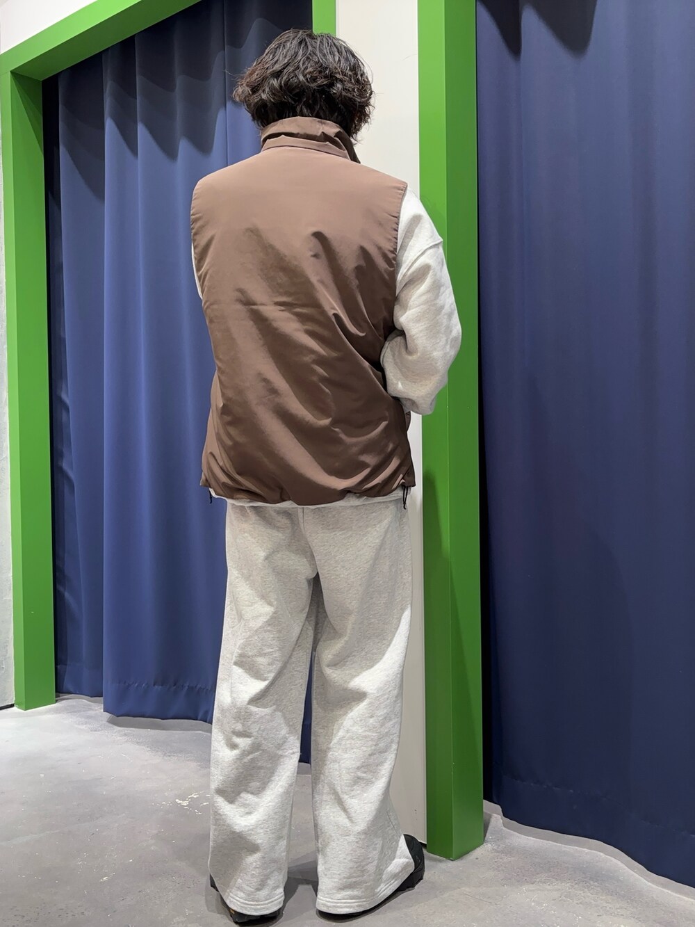 グレー系のスウェット、グレー系のスウェットパンツ、ブラウン系のベストを着用したメンズの冬コーディネートの5枚目の写真