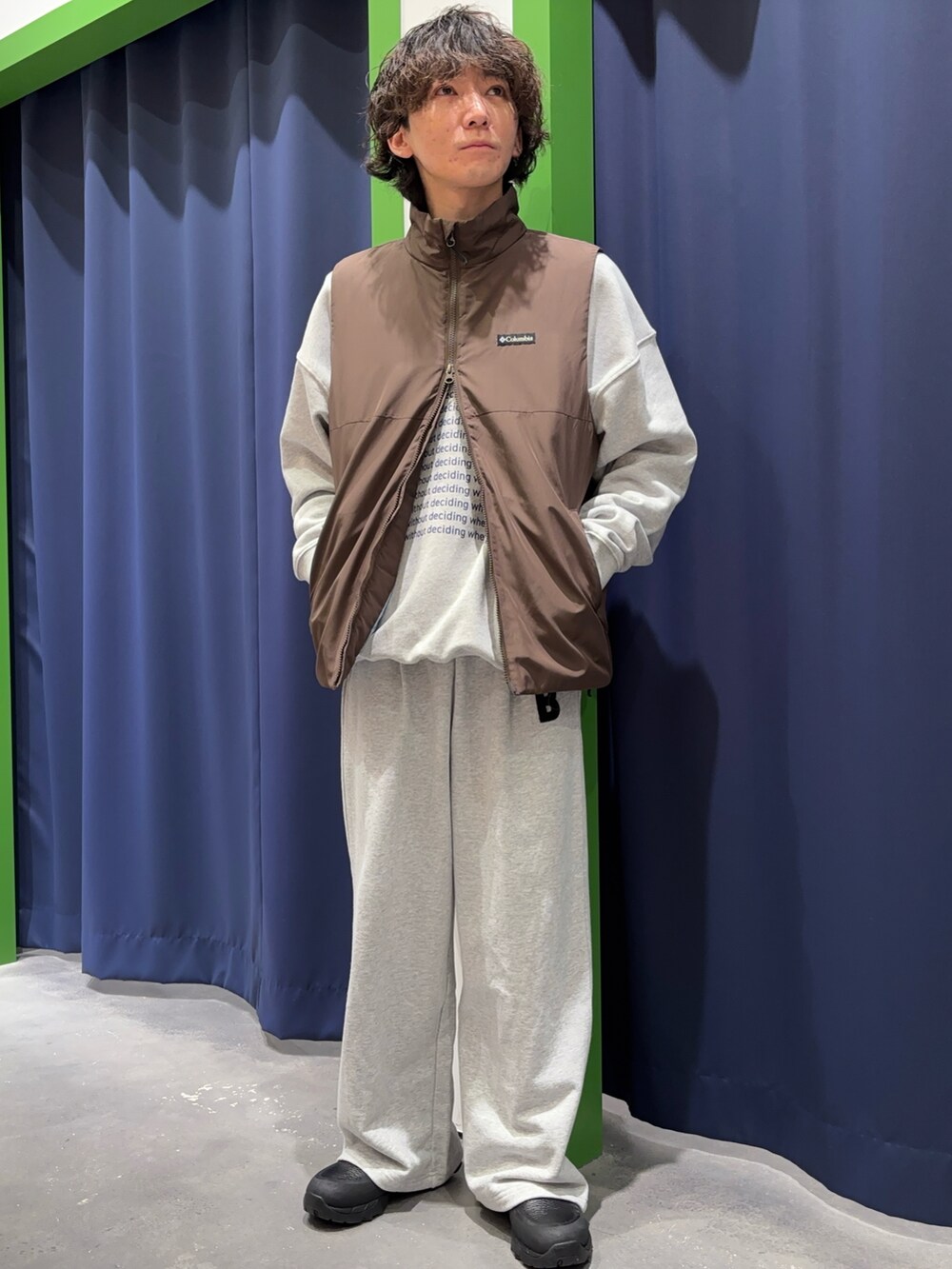 グレー系のスウェット、グレー系のスウェットパンツ、ブラウン系のベストを着用したメンズの冬コーディネートの3枚目の写真