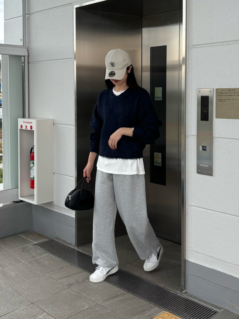ホワイト系のTシャツ/カットソー、ブルー系のニット/セーター、ブラック系のボストンバッグを着用したレディースの秋コーディネートの3枚目の写真