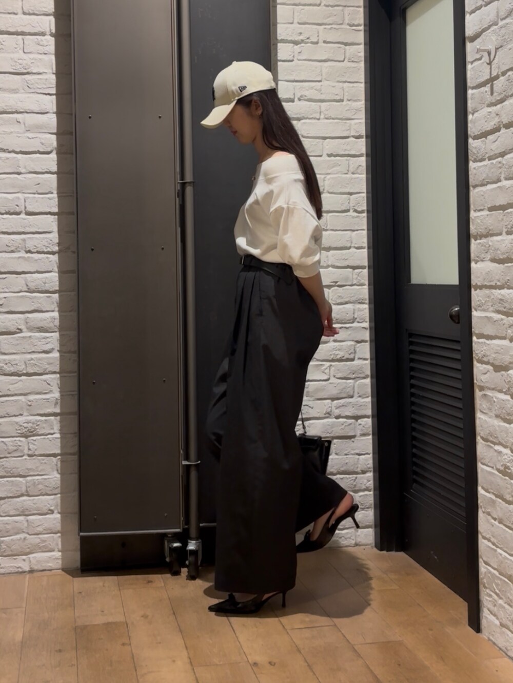 ホワイト系のスウェット、ブラック系のその他パンツ、ブラック系のハンドバッグを着用したレディースの夏コーディネートの3枚目の写真