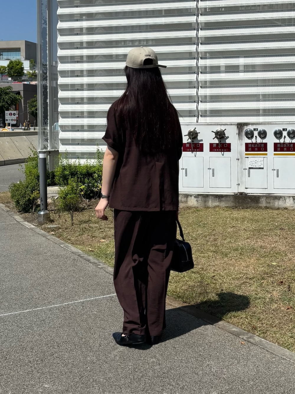 ブラウン系のテーラードジャケット、ブラウン系のその他パンツ、ブラック系のボストンバッグを着用したレディースの春コーディネートの3枚目の写真