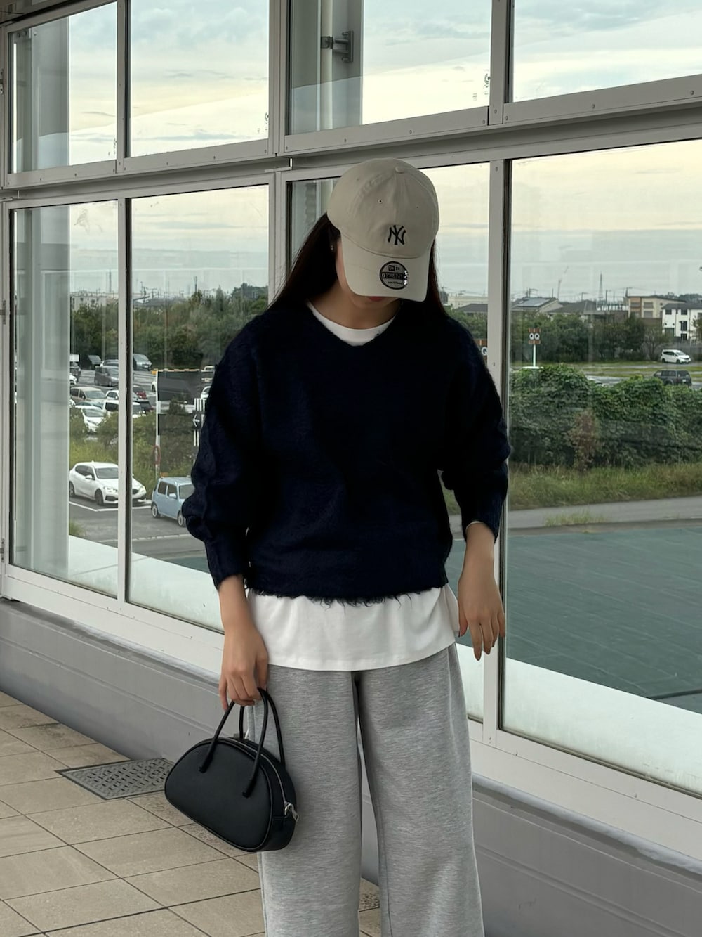 ホワイト系のTシャツ/カットソー、ブルー系のニット/セーター、ブラック系のボストンバッグを着用したレディースの秋コーディネートの4枚目の写真