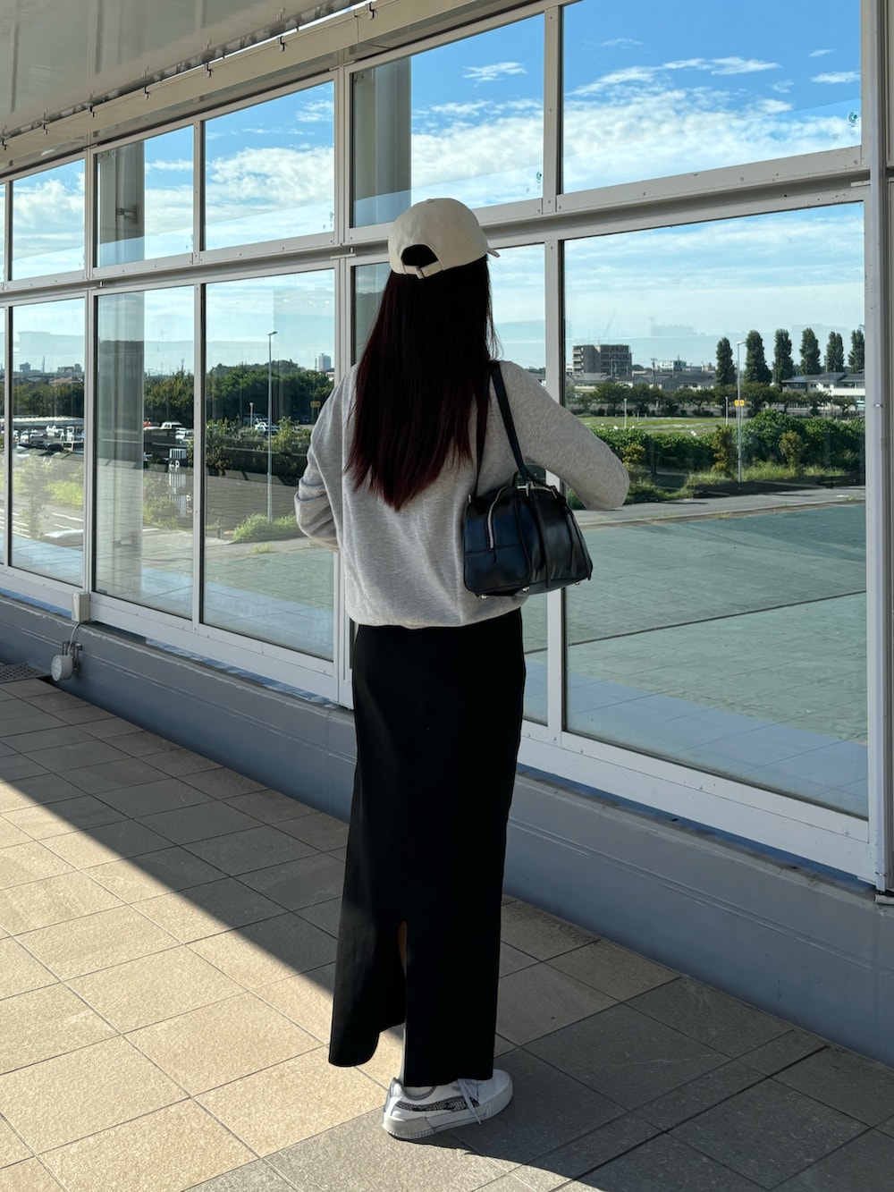 ブラック系のスカート、ブラック系のボストンバッグを着用したレディースの夏コーディネートの4枚目の写真