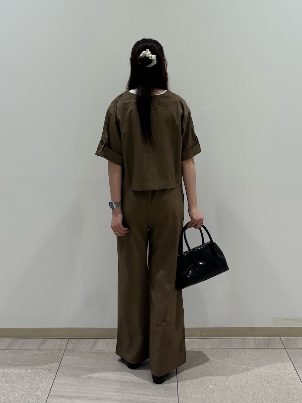 ブラウン系のノーカラージャケット、ブラウン系のその他パンツ、ブラック系のハンドバッグを着用したレディースの夏コーディネートの2枚目の写真