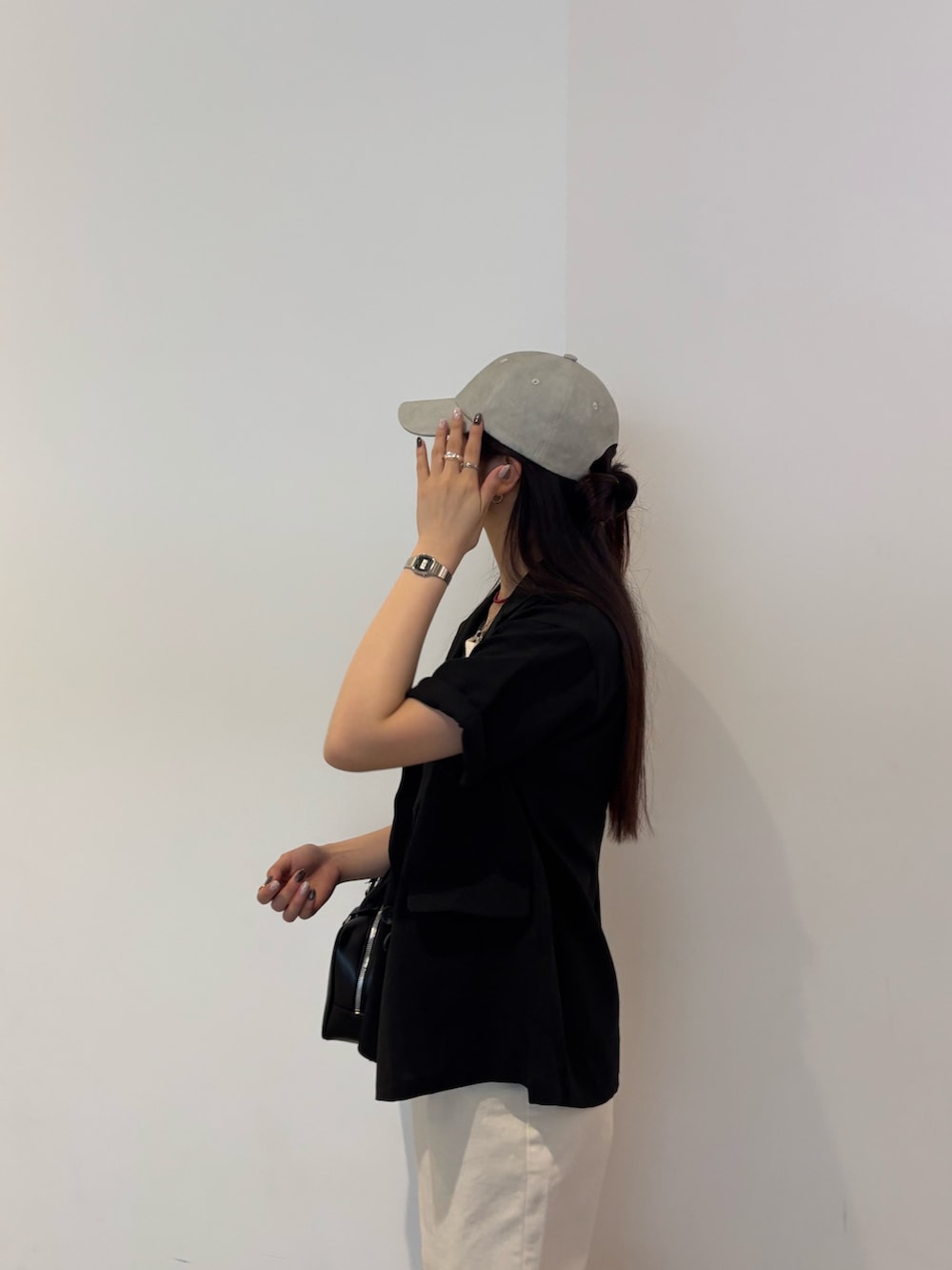 ブラック系のテーラードジャケット、ホワイト系のTシャツ/カットソー、ブラック系のボストンバッグを着用したレディースの夏コーディネートの2枚目の写真