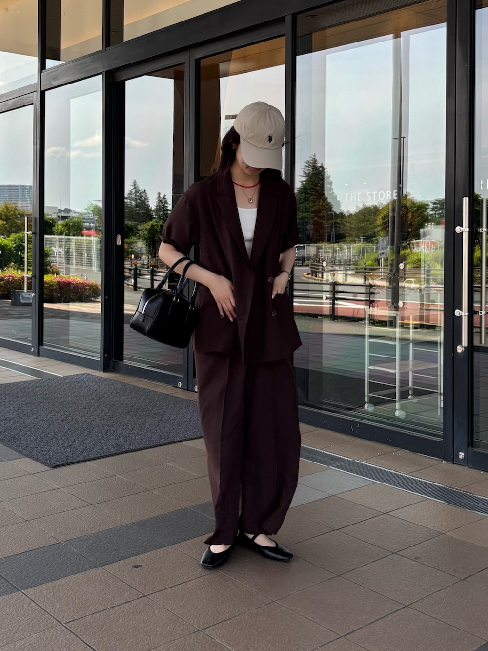 ブラウン系のテーラードジャケット、ブラウン系のその他パンツ、ブラック系のボストンバッグを着用したレディースの春コーディネートの2枚目の写真