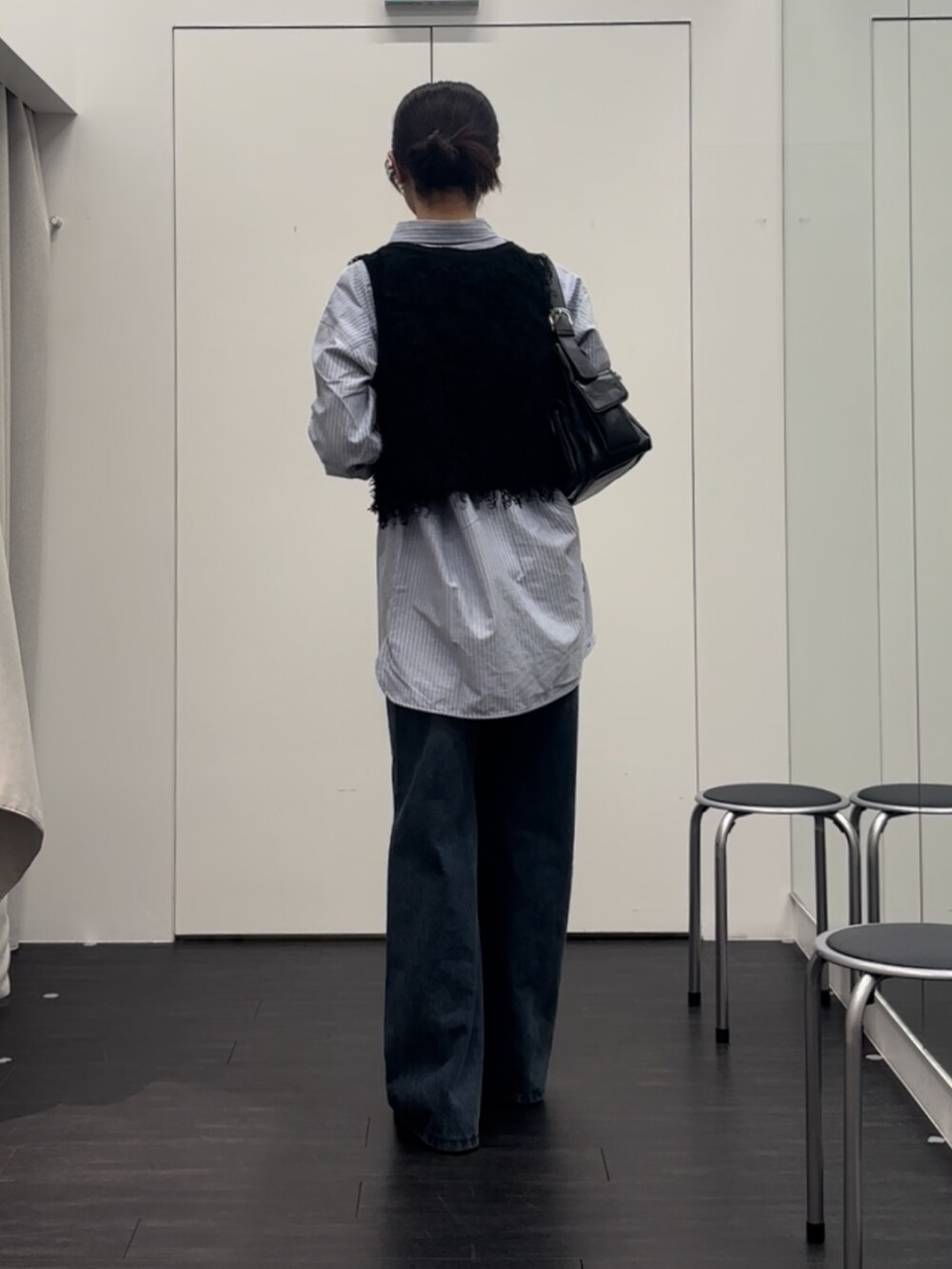 ブルー系のシャツ/ブラウス、ブラック系のベスト、ブラック系のショルダーバッグを着用したレディースの秋コーディネートの2枚目の写真