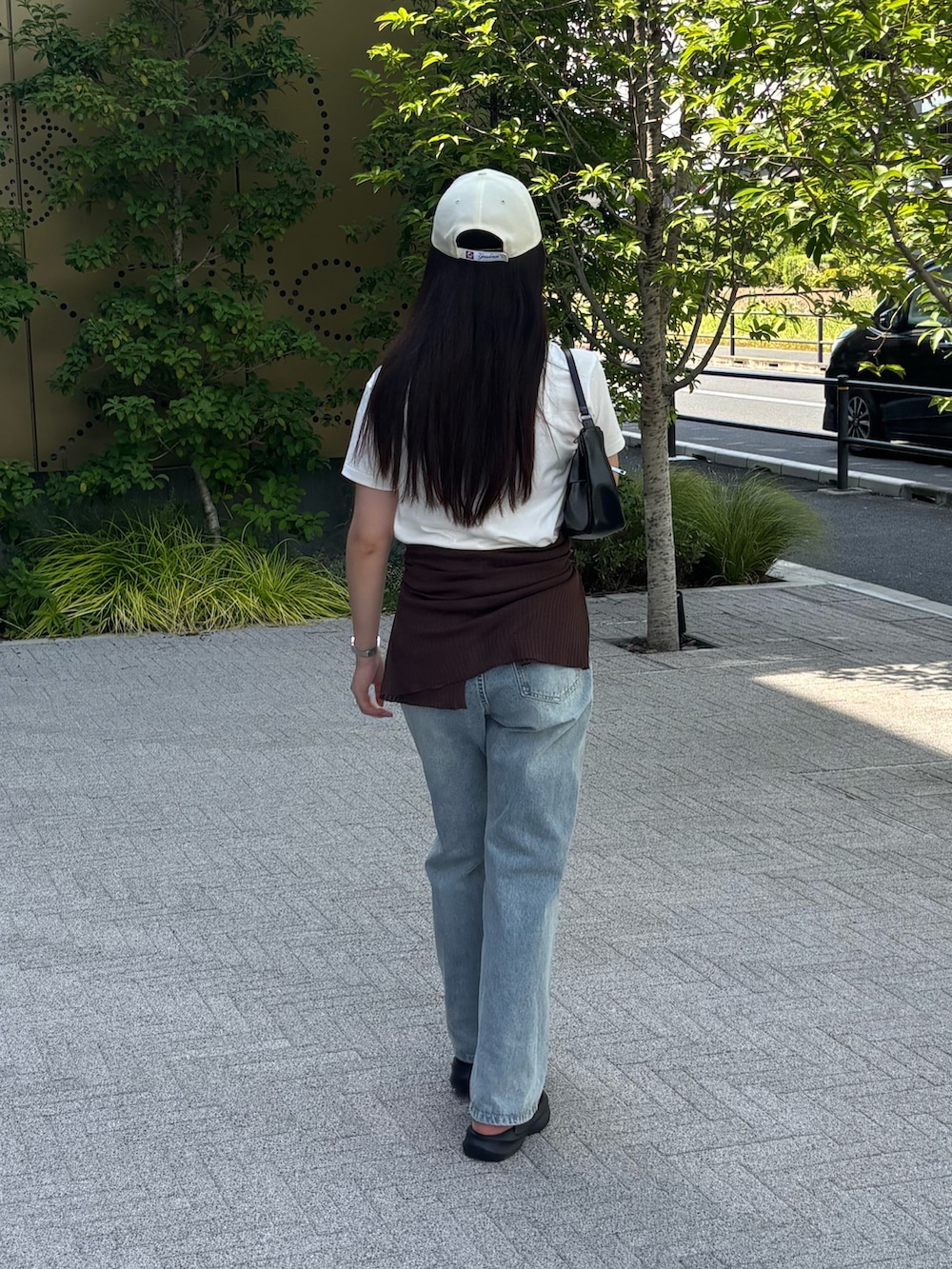 ホワイト系のTシャツ/カットソー、ブラウン系のカーディガン/ボレロ、ブルー系のデニムパンツを着用したレディースの夏コーディネートの3枚目の写真