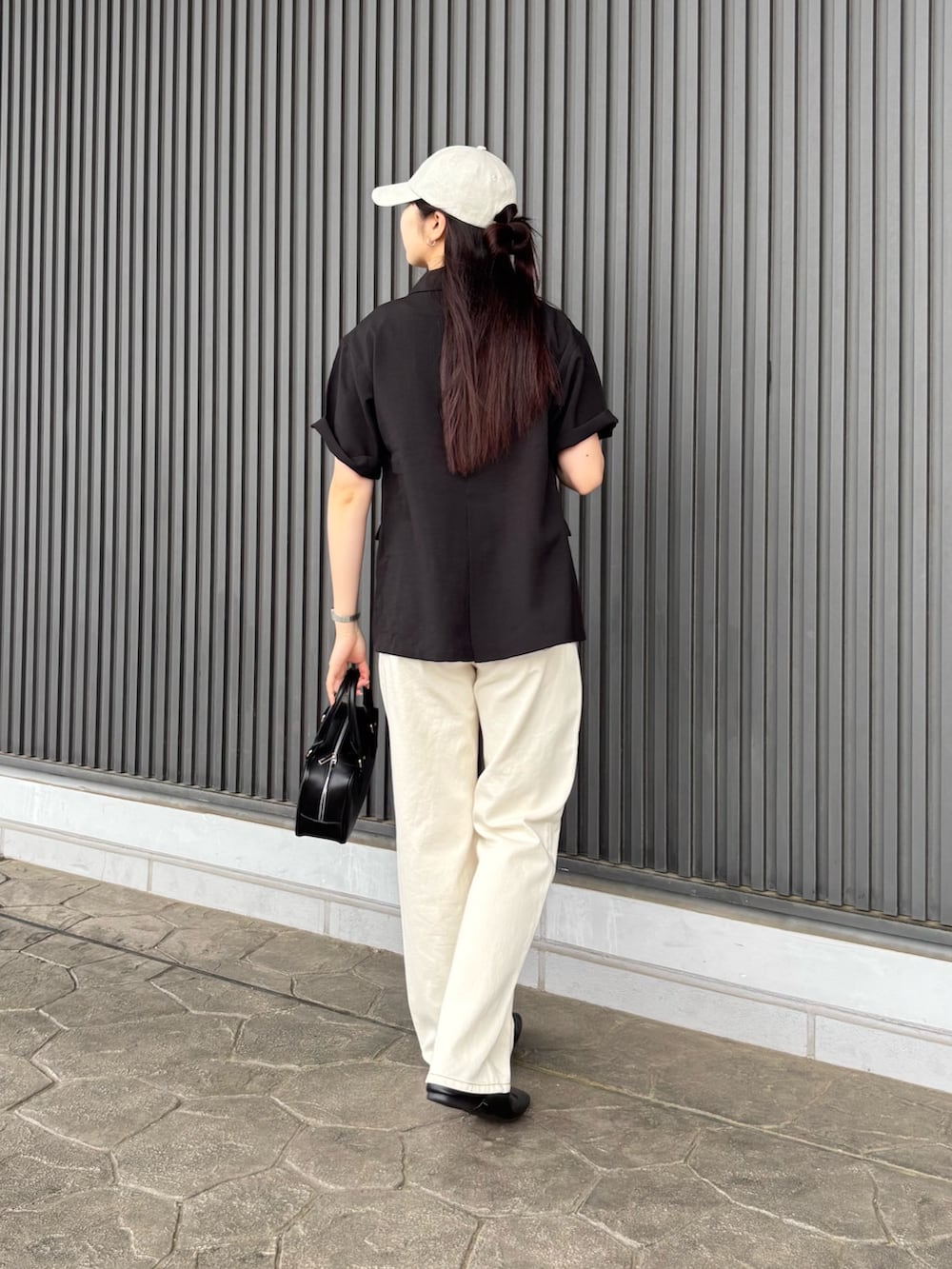ブラック系のテーラードジャケット、ホワイト系のTシャツ/カットソー、ブラック系のボストンバッグを着用したレディースの夏コーディネートの4枚目の写真