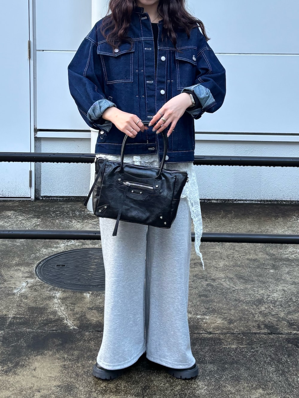 ブルー系のデニムジャケット、ブラック系のTシャツ/カットソー、グレー系のスウェットパンツを着用したレディースの春コーディネートの3枚目の写真