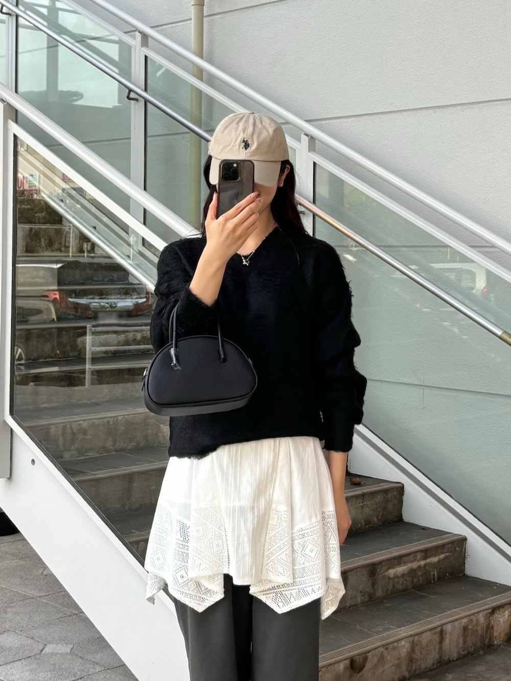 ブラック系のニット/セーター、グレー系のスラックスを着用したレディースの秋コーディネートの2枚目の写真