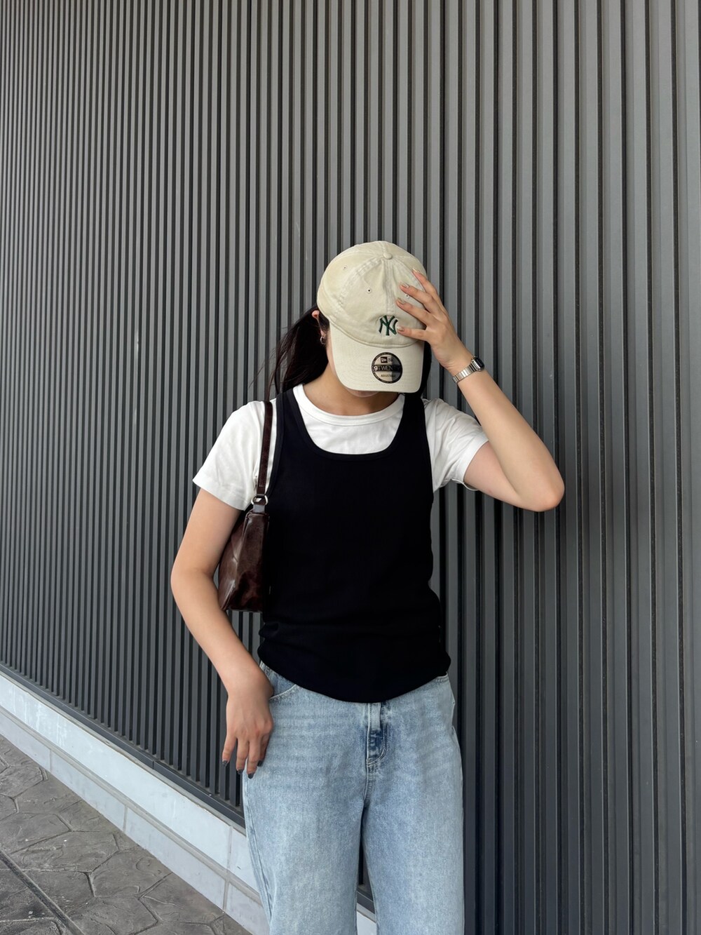 ホワイト系のTシャツ/カットソー、ブラック系のタンクトップ、ブルー系のデニムパンツを着用したレディースの夏コーディネートの3枚目の写真