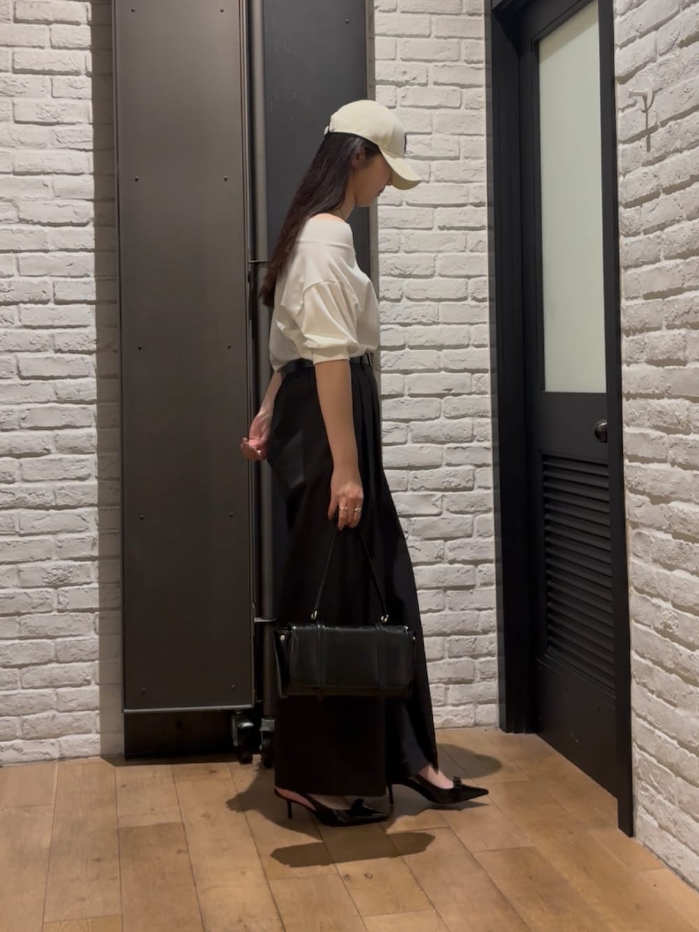 ホワイト系のスウェット、ブラック系のその他パンツ、ブラック系のハンドバッグを着用したレディースの夏コーディネートの2枚目の写真