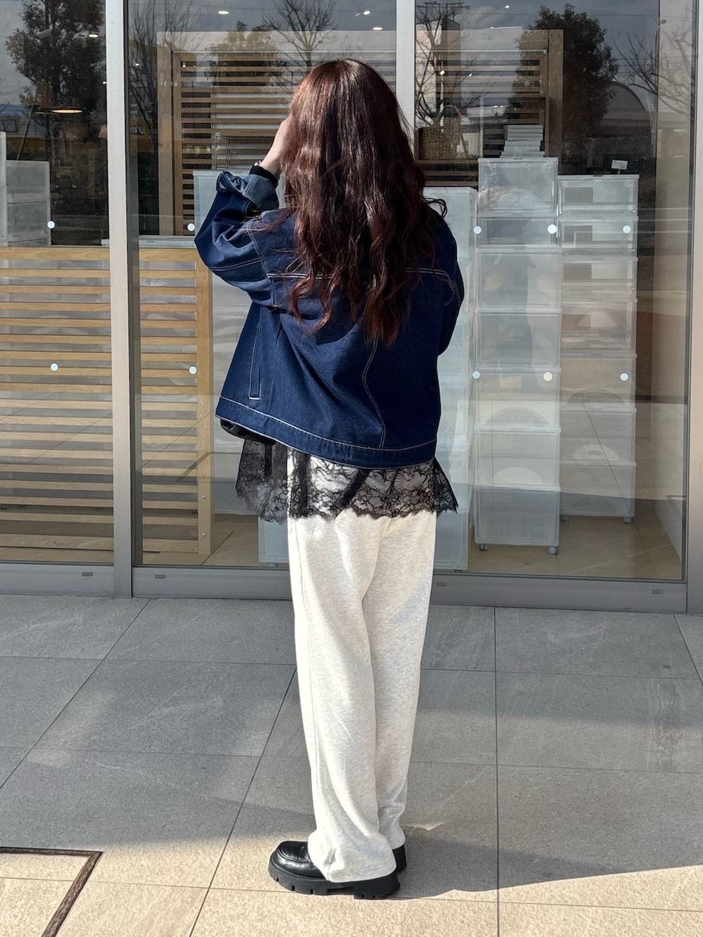 ブルー系のデニムジャケット、ブラック系のTシャツ/カットソー、ブラック系のハンドバッグを着用したレディースの春コーディネートの2枚目の写真