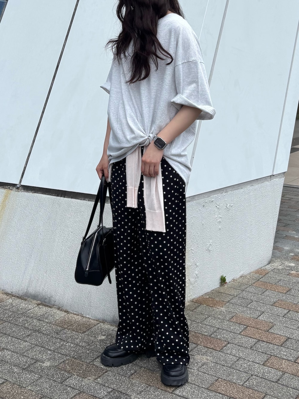 グレー系のTシャツ/カットソー、ピンク系のカーディガン/ボレロ、ブラック系のボストンバッグを着用したレディースの春コーディネートの3枚目の写真