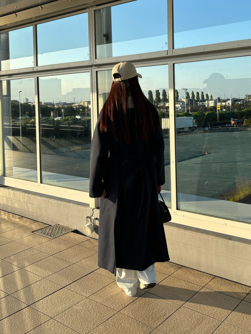ブルー系のジャケット/アウター、ホワイト系のデニムパンツ、ブラック系のボストンバッグを着用したレディースの秋コーディネートの3枚目の写真