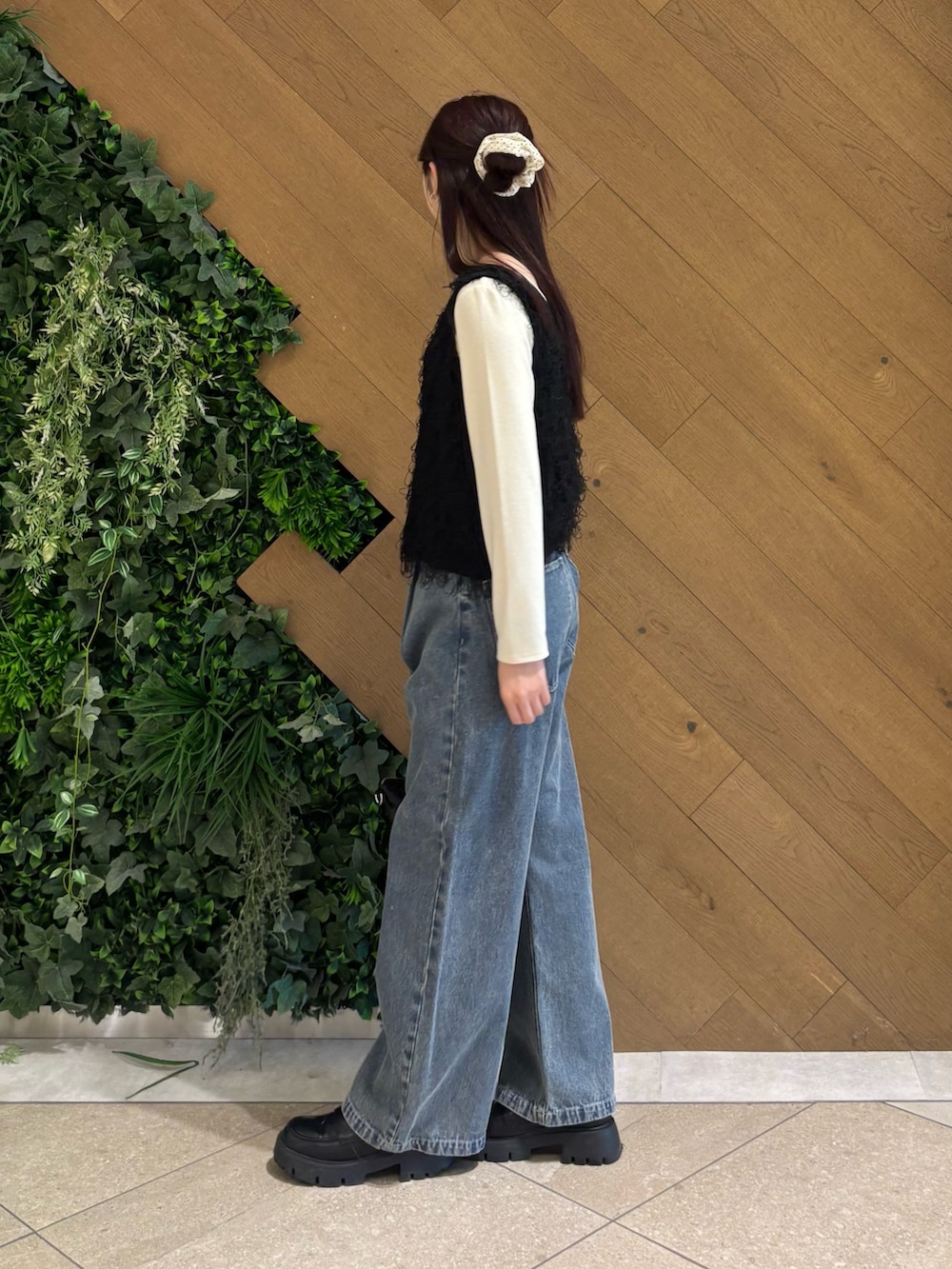 ホワイト系のTシャツ/カットソー、ブラック系のベスト、ブルー系のデニムパンツを着用したレディースの春コーディネートの2枚目の写真