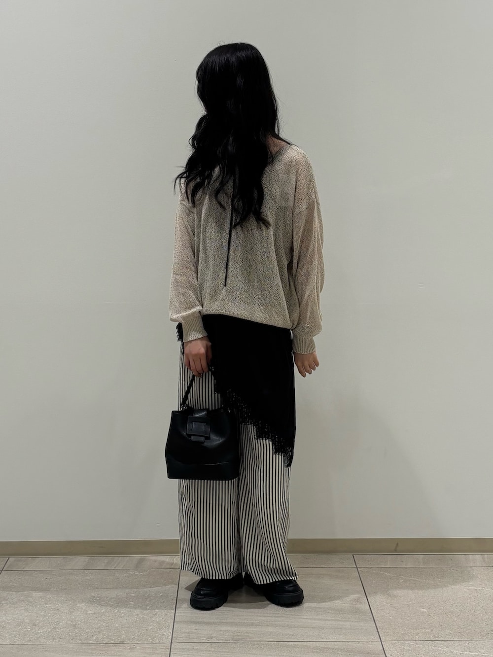 ベージュ系のニット/セーター、ブラック系のシャツ/ブラウス、ブルー系のその他パンツを着用したレディースの春コーディネートの2枚目の写真