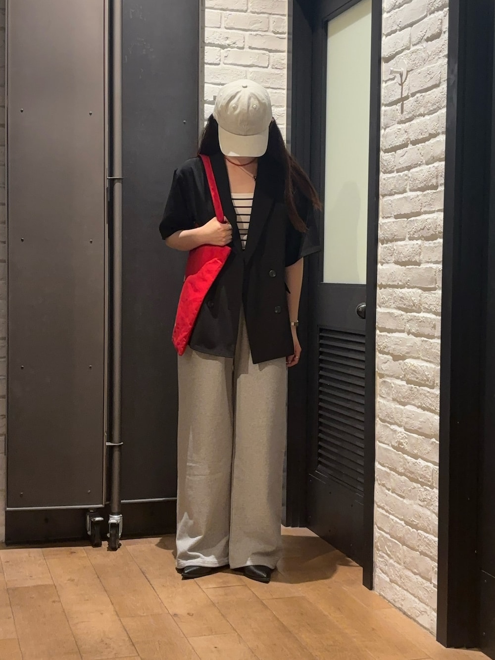 ブラック系のテーラードジャケット、グレー系のスウェットパンツ、ホワイト系のキャミソールを着用したレディースの夏コーディネートの3枚目の写真