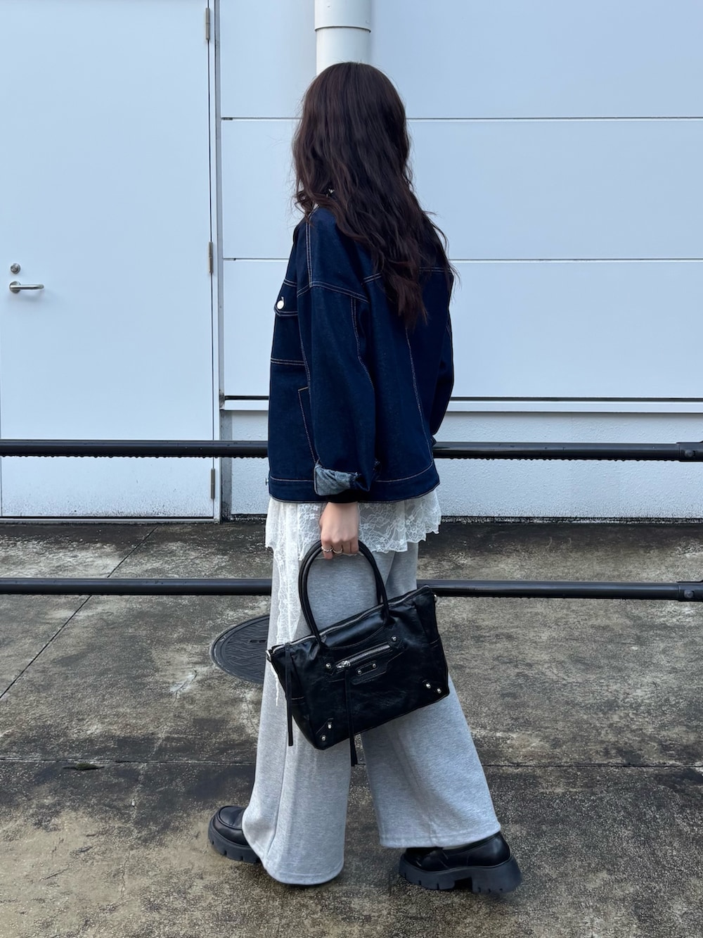 ブルー系のデニムジャケット、ブラック系のTシャツ/カットソー、グレー系のスウェットパンツを着用したレディースの春コーディネートの2枚目の写真