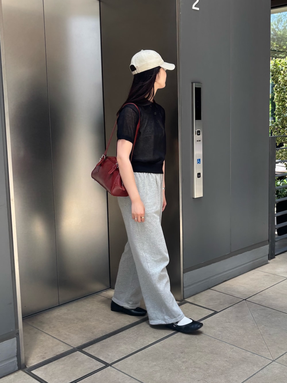 ブラック系のニット/セーター、グレー系のスウェットパンツ、レッド系のボストンバッグを着用したレディースの夏コーディネートの3枚目の写真