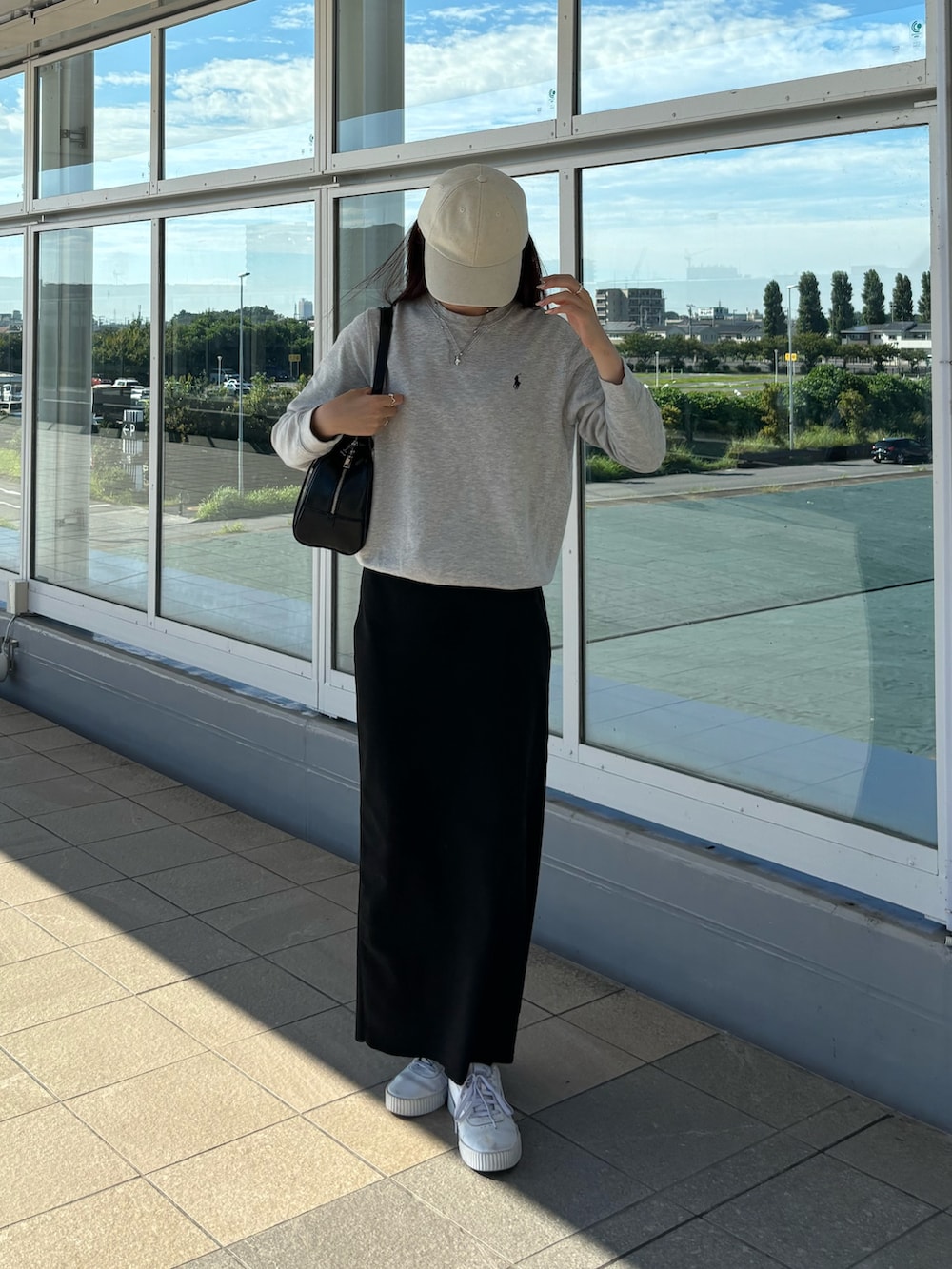 ブラック系のスカート、ブラック系のボストンバッグを着用したレディースの夏コーディネートの2枚目の写真
