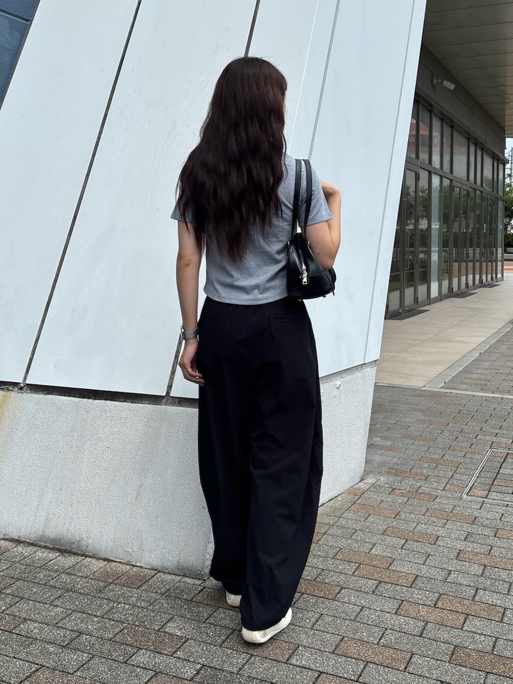 グレー系のTシャツ/カットソー、ブラック系のボストンバッグ、ブラック系のその他パンツを着用したレディースの秋コーディネートの2枚目の写真