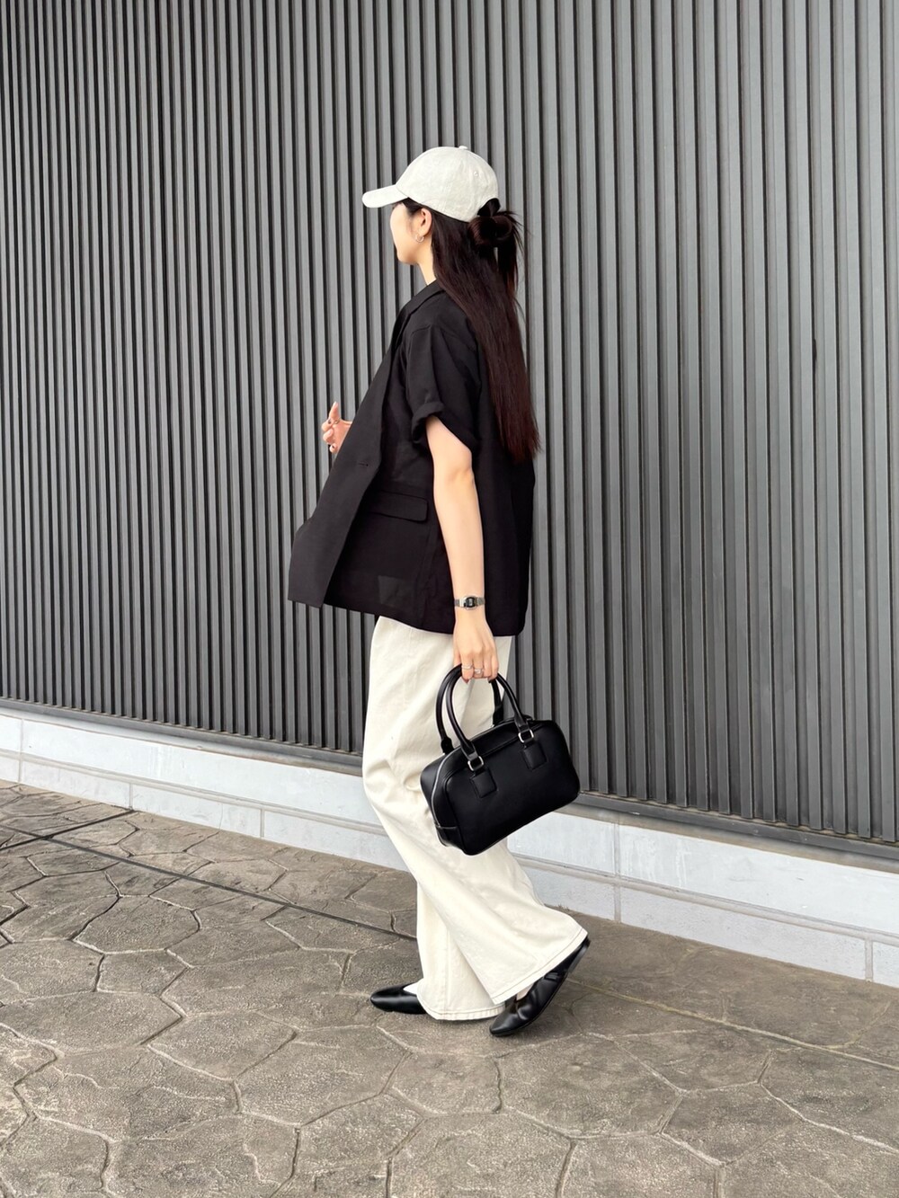 ブラック系のテーラードジャケット、ホワイト系のTシャツ/カットソー、ブラック系のボストンバッグを着用したレディースの夏コーディネートの3枚目の写真