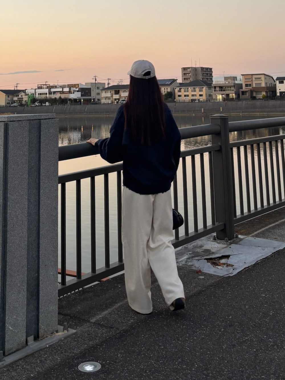 ブルー系のカーディガン/ボレロ、ブラック系のボストンバッグ、ホワイト系のその他パンツを着用したレディースの冬コーディネートの2枚目の写真