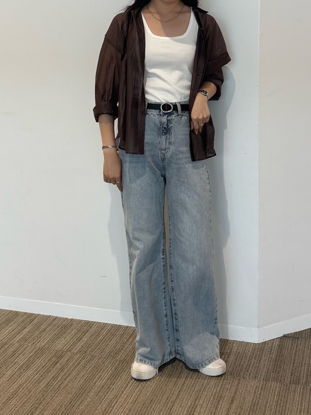 ホワイト系のタンクトップ、ブラウン系のシャツ/ブラウス、ブルー系のデニムパンツを着用したレディースの秋コーディネートの3枚目の写真