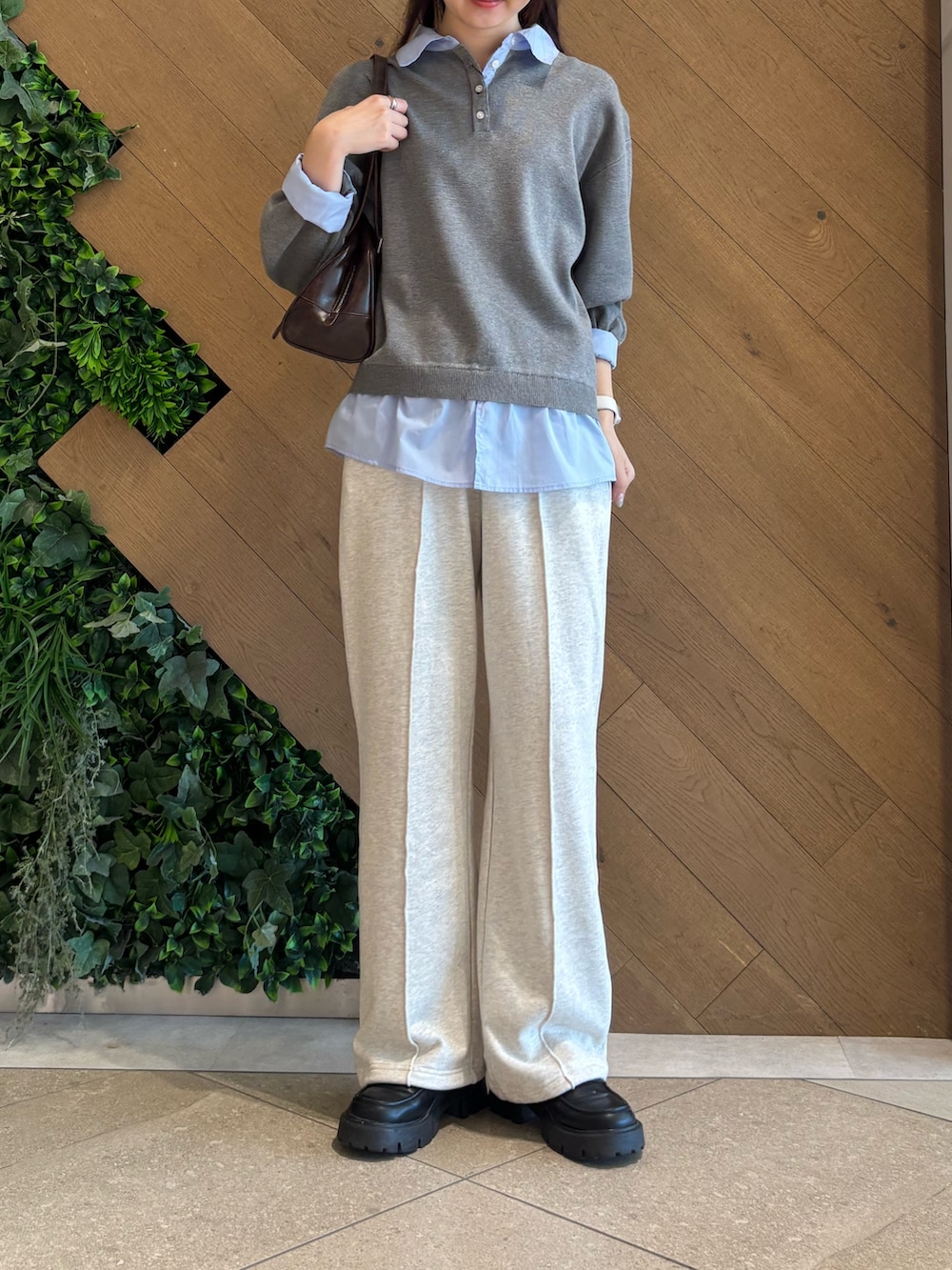 グレー系のニット/セーター、ホワイト系のスウェットパンツ、ブラウン系のボストンバッグを着用したレディースの春コーディネートの2枚目の写真