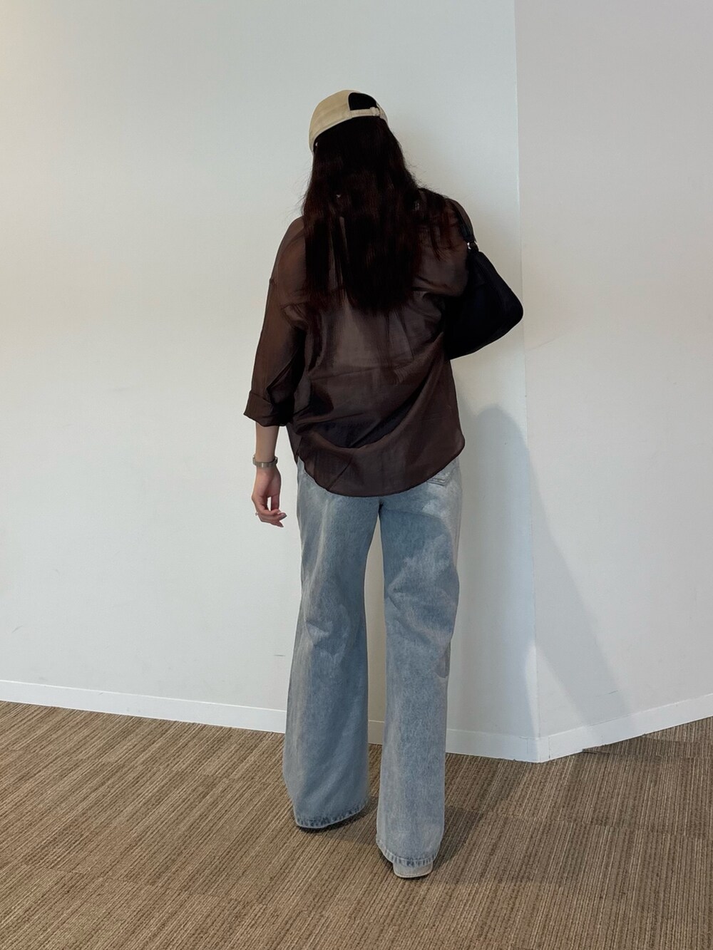 ホワイト系のタンクトップ、ブラウン系のシャツ/ブラウス、ブルー系のデニムパンツを着用したレディースの秋コーディネートの2枚目の写真