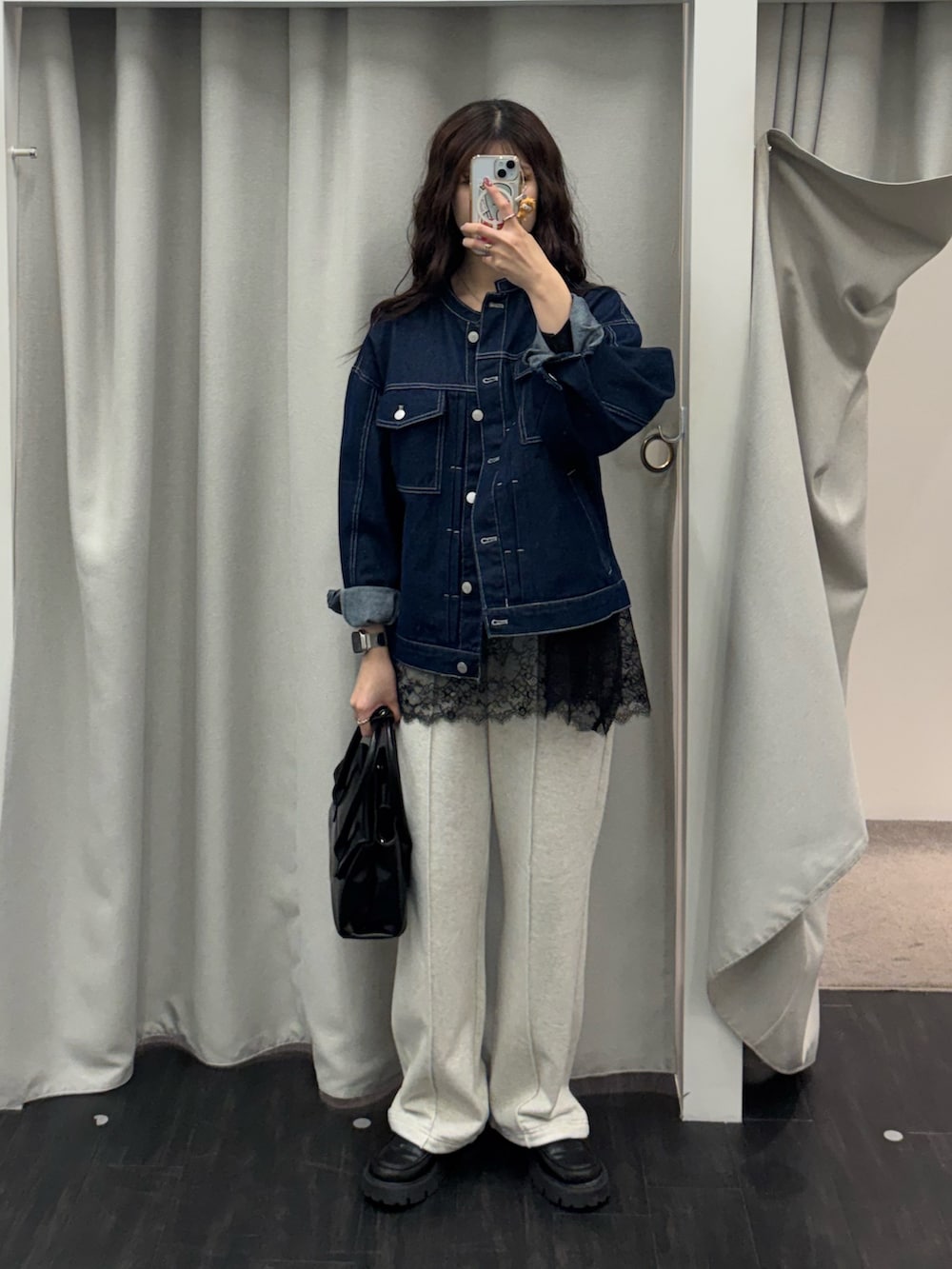 ブルー系のデニムジャケット、ブラック系のTシャツ/カットソー、ブラック系のハンドバッグを着用したレディースの春コーディネートの3枚目の写真