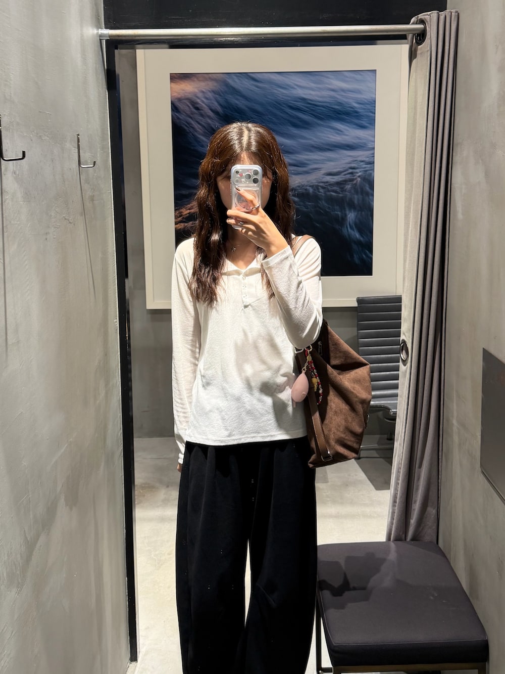ブラウン系のショルダーバッグ、ブラック系のスウェットパンツ、ホワイト系のTシャツ/カットソーを着用したレディースの秋コーディネートの2枚目の写真