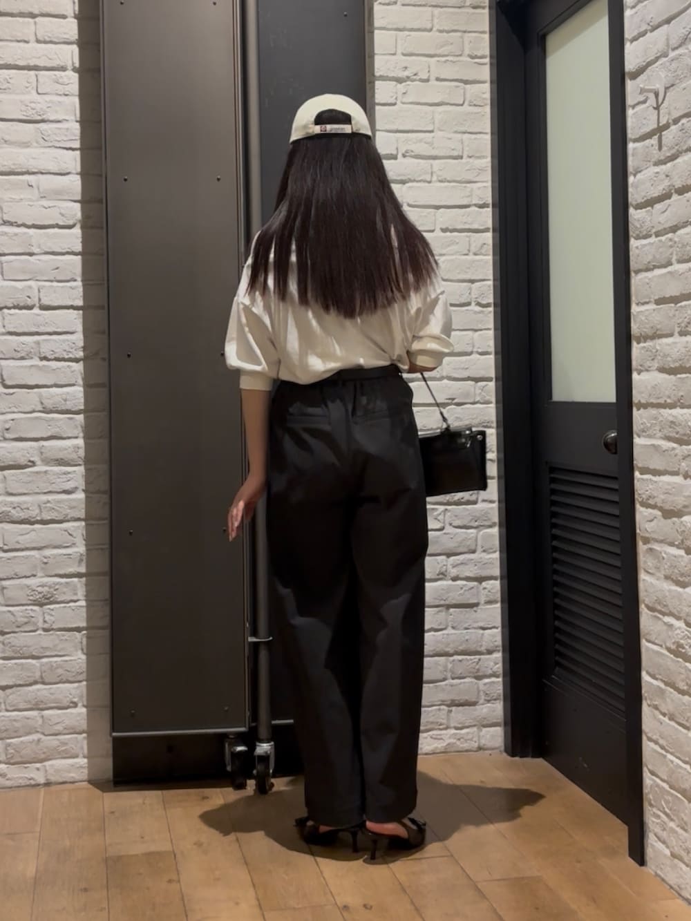 ホワイト系のスウェット、ブラック系のその他パンツ、ブラック系のハンドバッグを着用したレディースの夏コーディネートの4枚目の写真